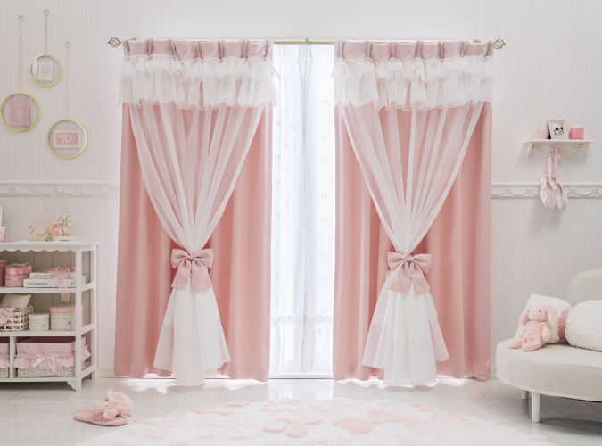 ボイルとリボンが特徴的なピンクの遮光カーテンを掃き出し窓に設置した画像