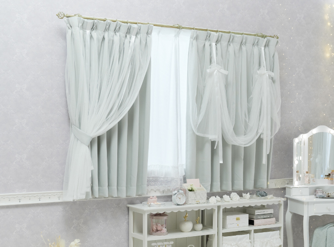 ボイルをリボンでまとめたグレーの遮光カーテンを腰高窓に設置した画像