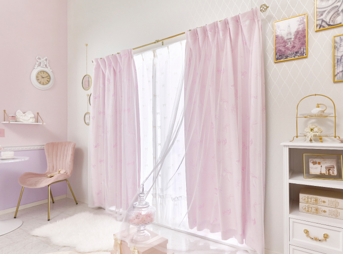 リボン柄のボイルが重なった遮光カーテを掃き出し窓に設置した画像